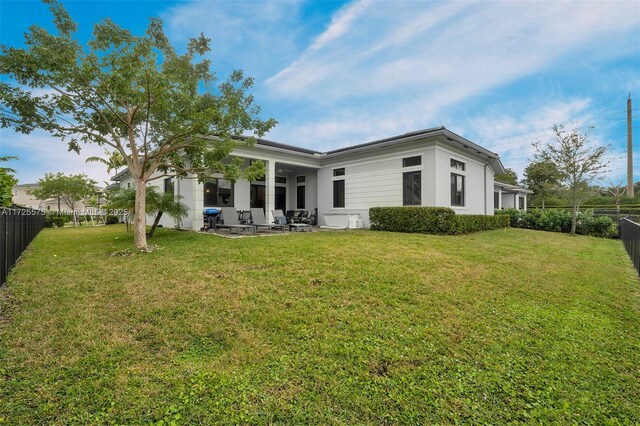 back of property with a patio area and a yard