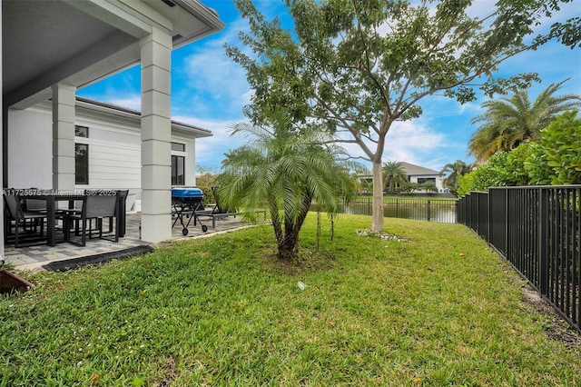 view of yard with a patio area, a water view, and a fenced backyard