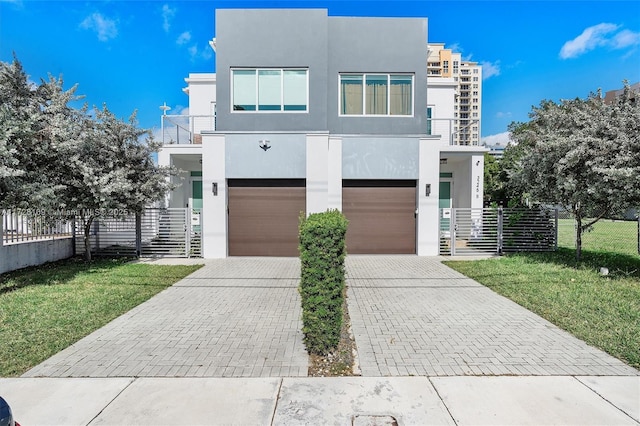 contemporary home with a front lawn, a garage, and a balcony