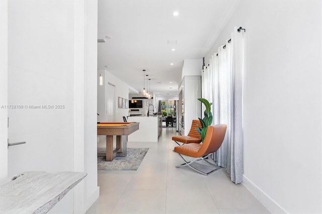 hallway featuring sink and light tile patterned flooring