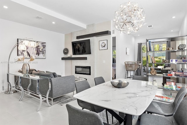 dining room featuring a fireplace and an inviting chandelier