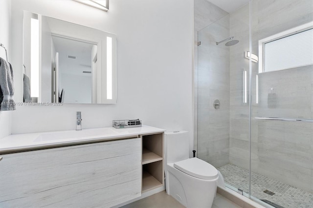 bathroom featuring toilet, vanity, and a shower with door