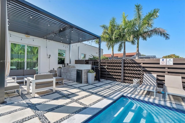 view of swimming pool featuring an outdoor kitchen, an outdoor hangout area, a bar, a pergola, and a patio