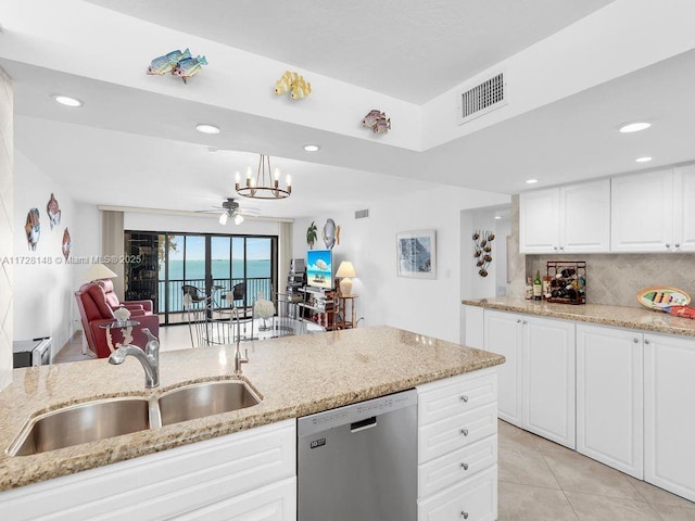 kitchen featuring sink, white cabinetry, decorative light fixtures, stainless steel dishwasher, and light stone countertops