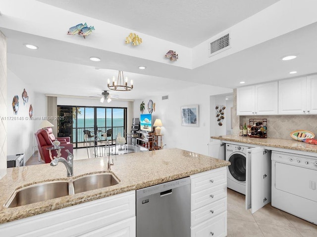 kitchen with pendant lighting, washer / clothes dryer, stainless steel dishwasher, and sink