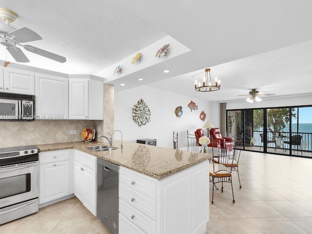 kitchen with sink, kitchen peninsula, stainless steel appliances, decorative backsplash, and white cabinets