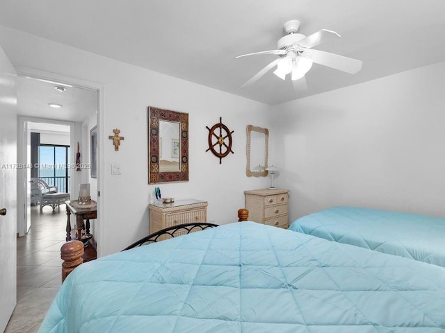 tiled bedroom featuring ceiling fan