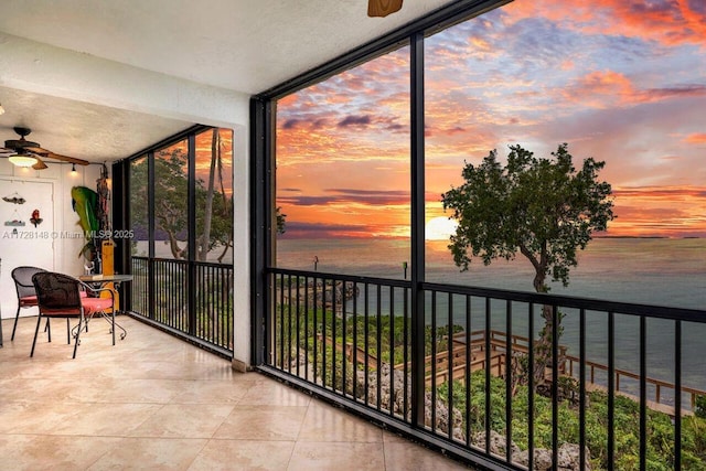 sunroom with a water view and ceiling fan