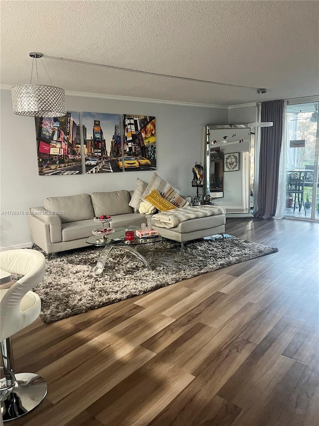 living room featuring hardwood / wood-style flooring, a textured ceiling, and ornamental molding