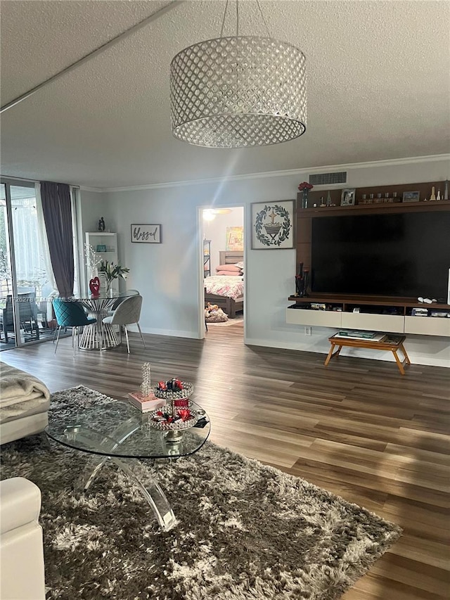 living room with hardwood / wood-style flooring, a textured ceiling, and ornamental molding