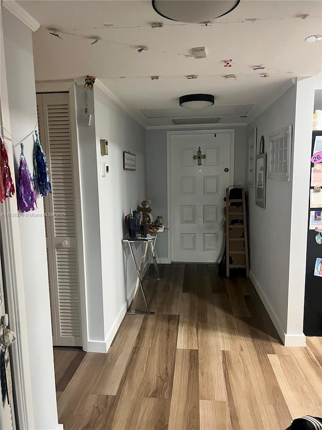 hallway featuring light wood-type flooring and ornamental molding