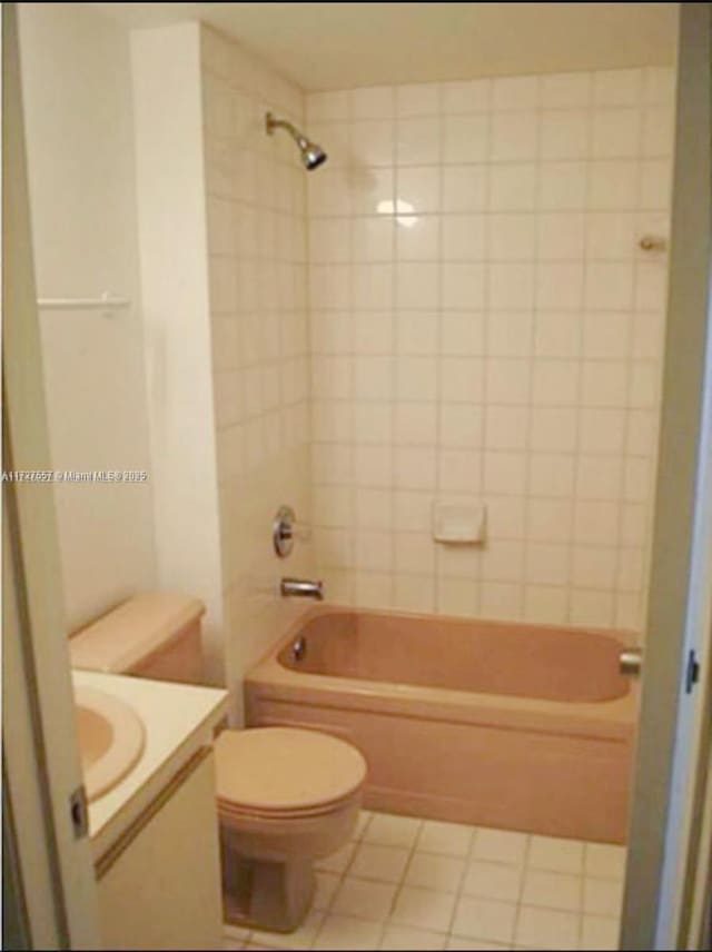 full bathroom featuring toilet, tile patterned flooring, tiled shower / bath combo, and vanity