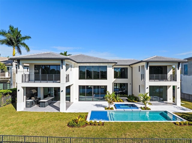 back of house featuring a lawn, a patio area, a balcony, and a fenced in pool