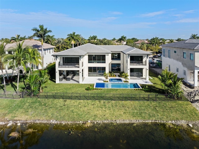 back of property featuring a fenced in pool, a patio area, a lawn, and a balcony