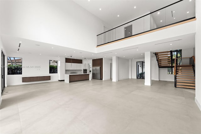 unfurnished living room with a towering ceiling