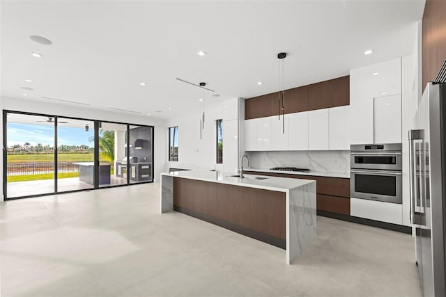 kitchen with stainless steel appliances, pendant lighting, white cabinets, and sink