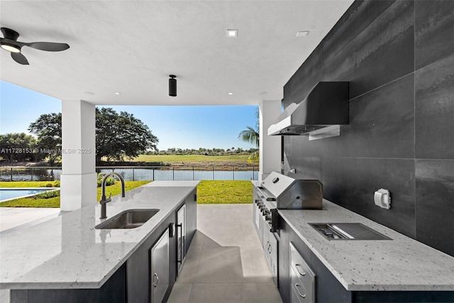 view of patio with an outdoor kitchen, sink, a pool, a water view, and area for grilling