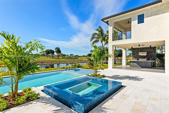 view of pool with an in ground hot tub, a patio area, an outdoor bar, a water view, and ceiling fan