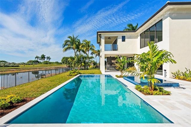 view of swimming pool with a water view, a lawn, and a patio