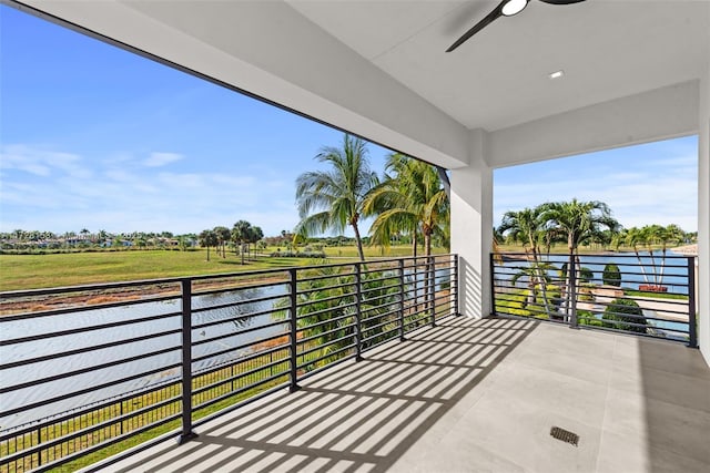 balcony featuring ceiling fan and a water view