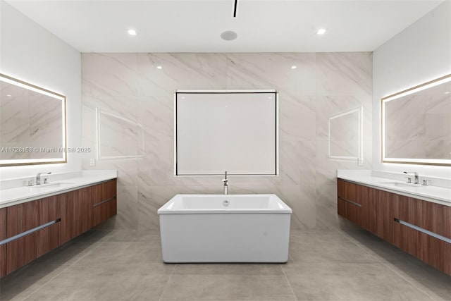 bathroom with vanity, a bathtub, and tile walls