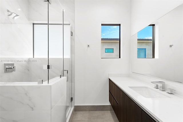 bathroom with tile patterned flooring, a shower with door, and vanity