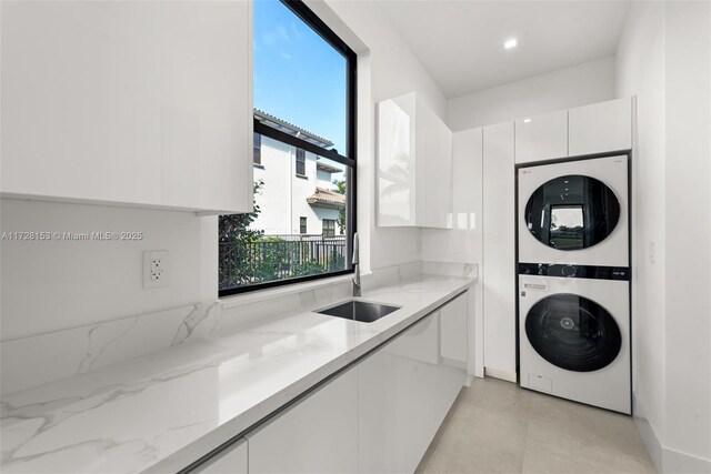 laundry room featuring sink and stacked washer and dryer