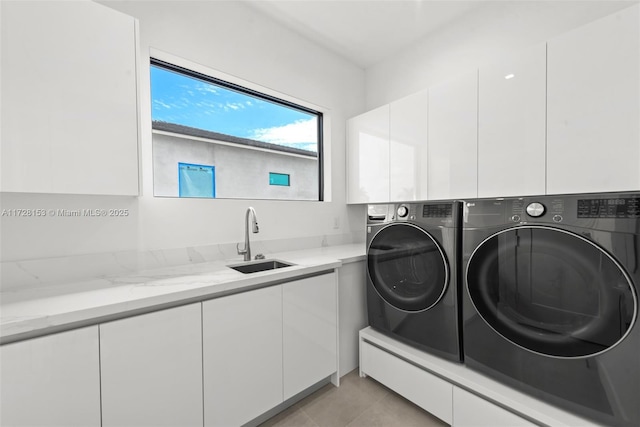 laundry room featuring washing machine and dryer, cabinets, light tile patterned flooring, and sink