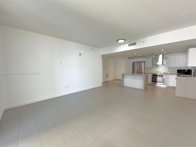 unfurnished living room with light tile patterned floors and sink