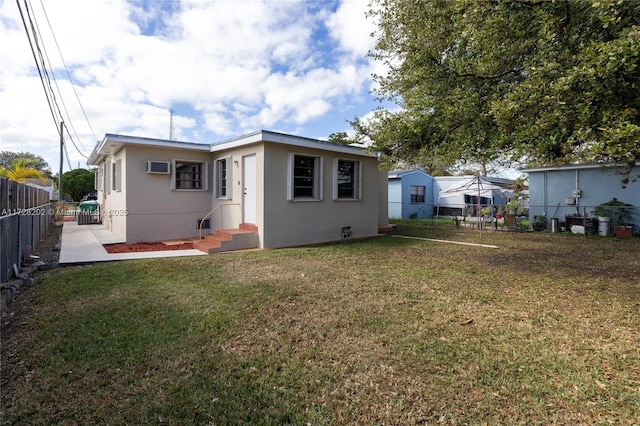 rear view of property with a yard and a wall mounted air conditioner