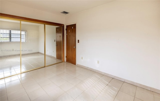 unfurnished bedroom featuring tile patterned floors and a closet