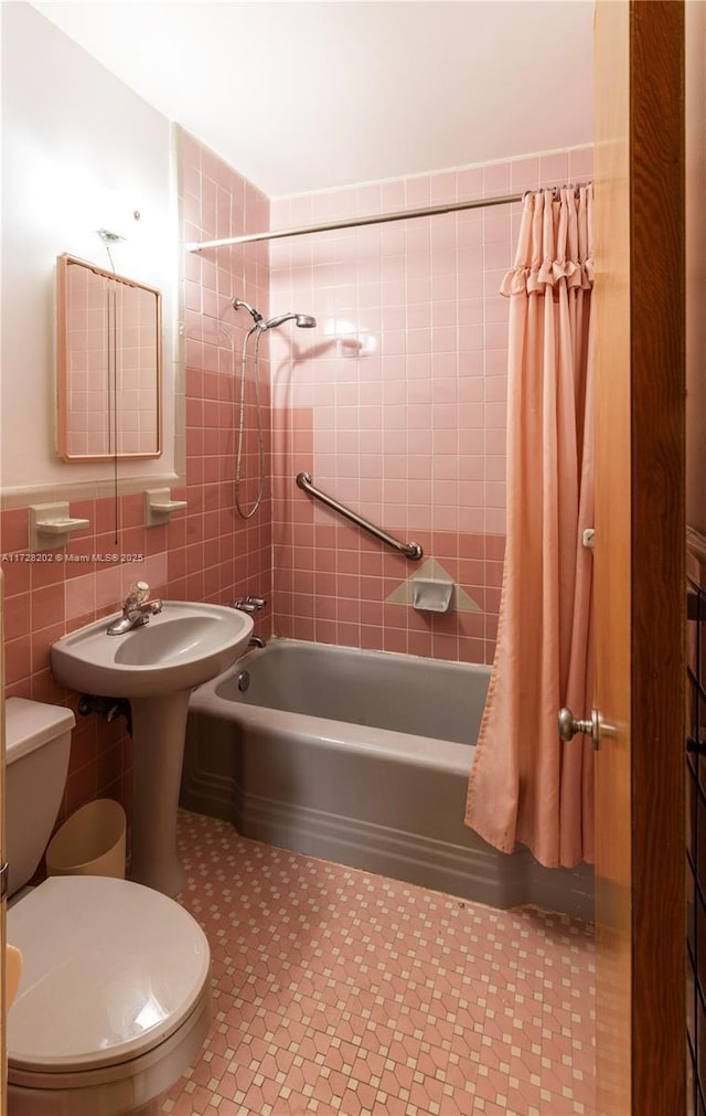 full bathroom featuring sink, tile walls, toilet, and shower / bath combo