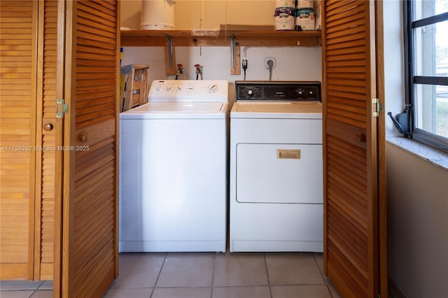 laundry room with washer and clothes dryer and light tile patterned flooring