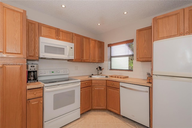 kitchen featuring decorative backsplash, white appliances, light tile patterned flooring, a textured ceiling, and sink