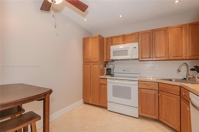 kitchen with tasteful backsplash, sink, white appliances, a textured ceiling, and light tile patterned floors