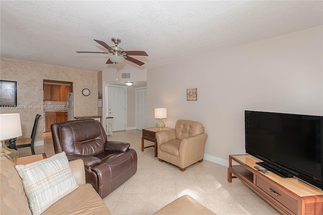 tiled living room featuring ceiling fan and a textured ceiling