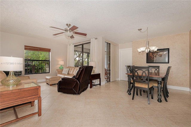 living room featuring ceiling fan with notable chandelier, a textured ceiling, and light tile patterned floors