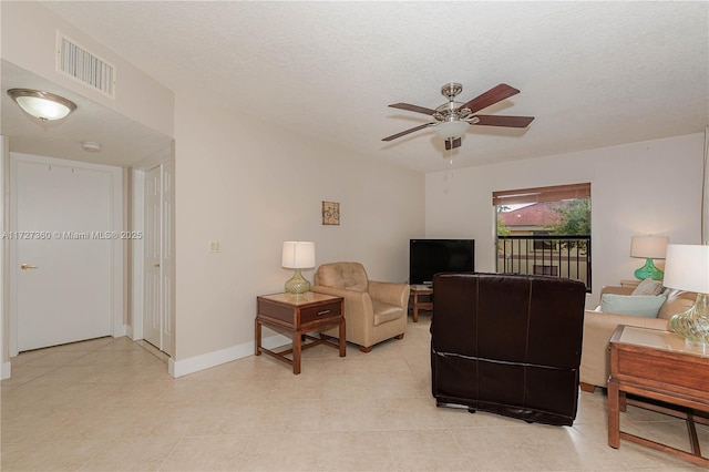 living room featuring a textured ceiling and ceiling fan