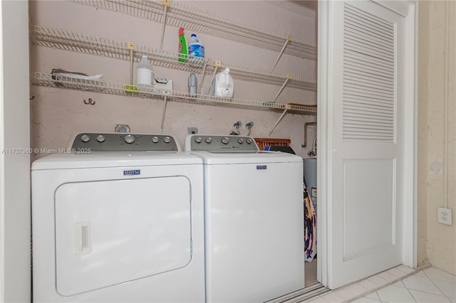 clothes washing area featuring separate washer and dryer and light tile patterned flooring