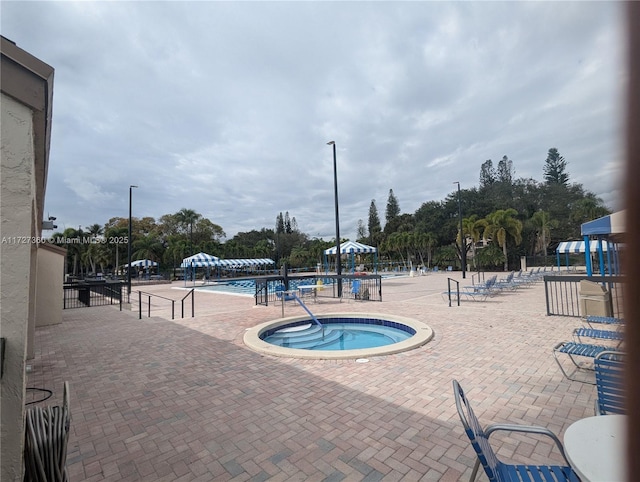 view of pool with a community hot tub and a patio area