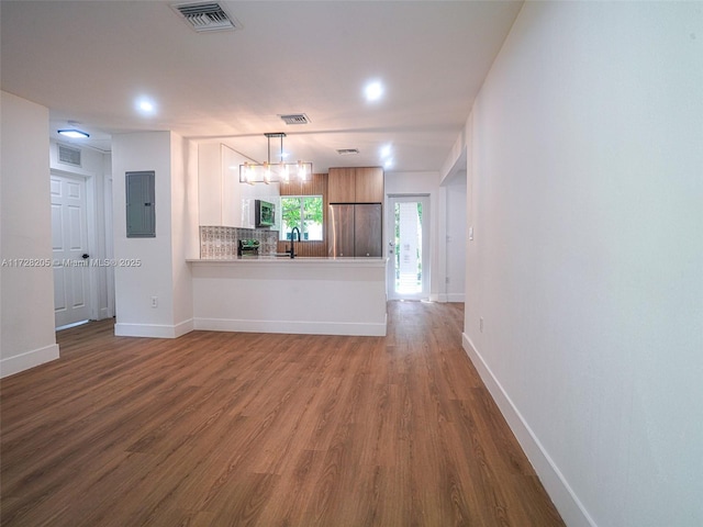 kitchen with electric panel, dark hardwood / wood-style flooring, stainless steel appliances, and tasteful backsplash