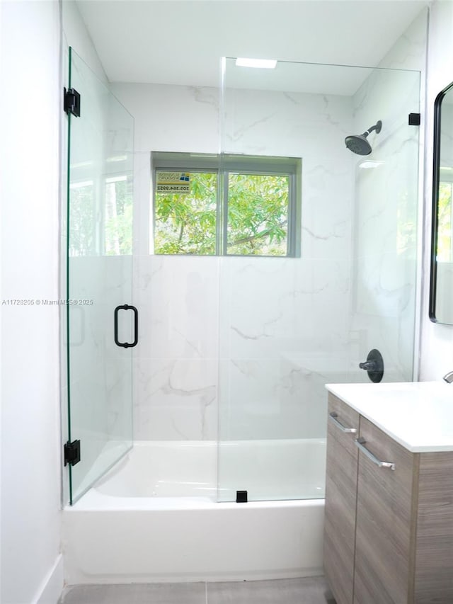 bathroom featuring vanity and shower / bath combination with glass door