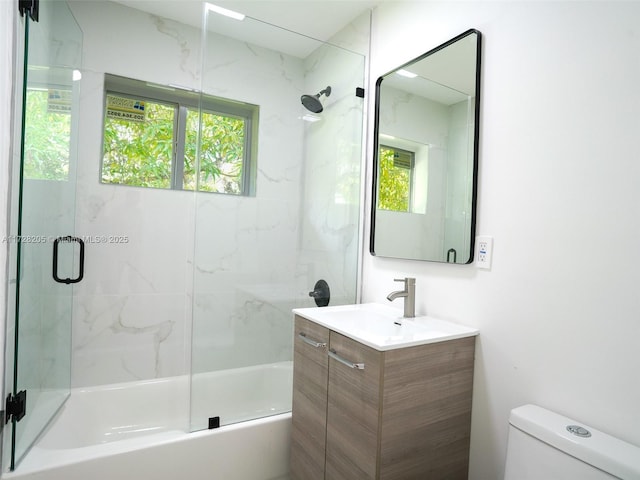 full bathroom with toilet, vanity, and shower / bath combination with glass door