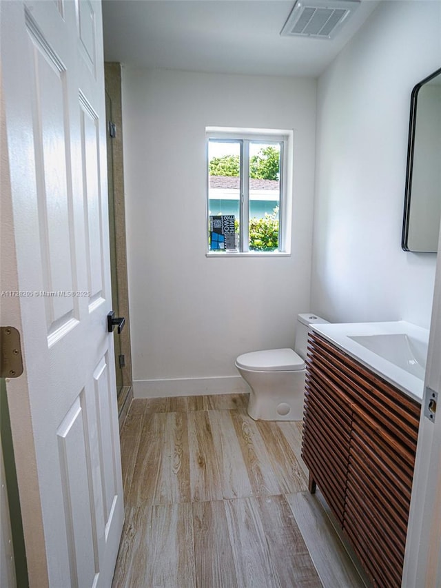 bathroom with hardwood / wood-style floors, toilet, and vanity