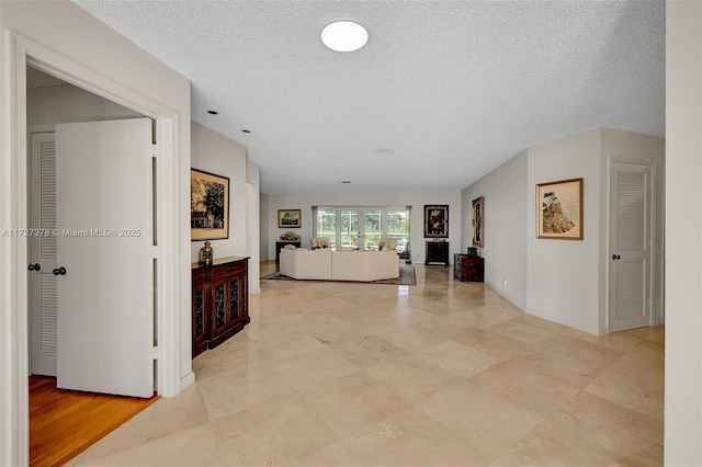 hall with a textured ceiling