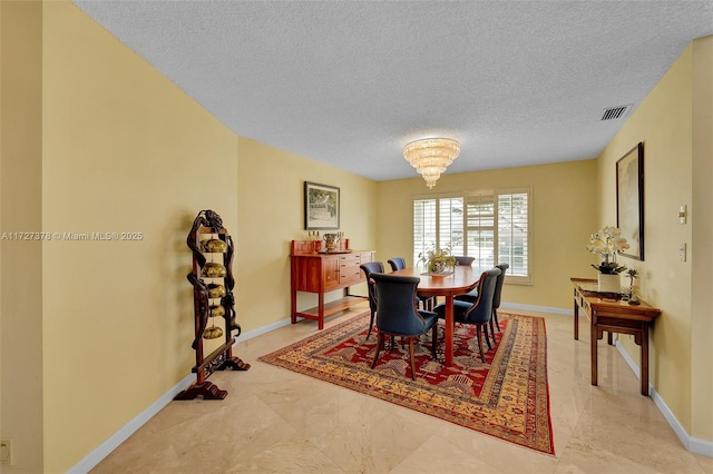 dining room with a textured ceiling and a chandelier