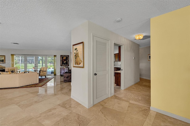 hall with a textured ceiling