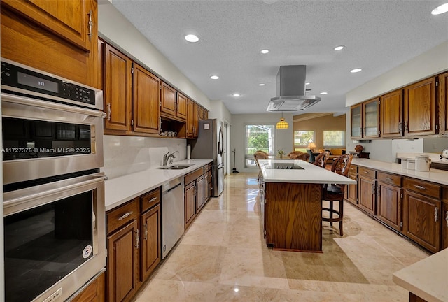 kitchen with a center island, decorative light fixtures, stainless steel appliances, island range hood, and a breakfast bar area