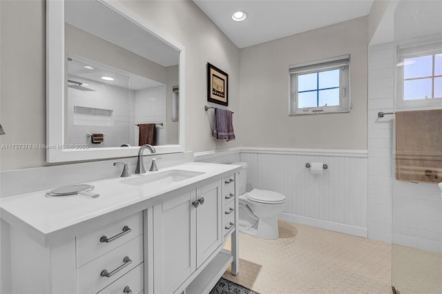 bathroom featuring toilet, walk in shower, and vanity