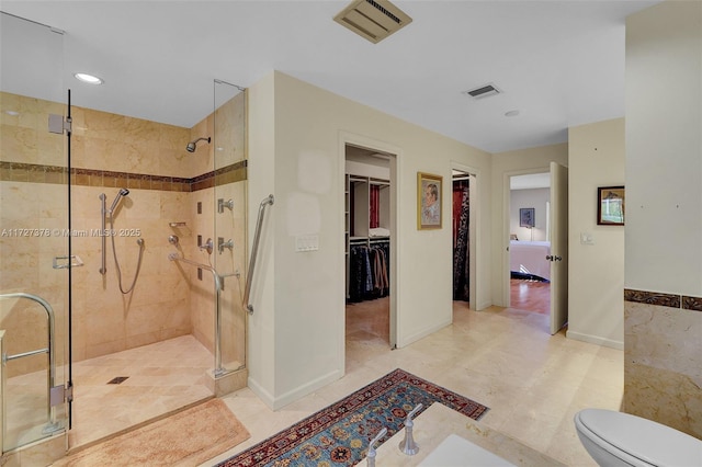 bathroom featuring toilet and a shower with door